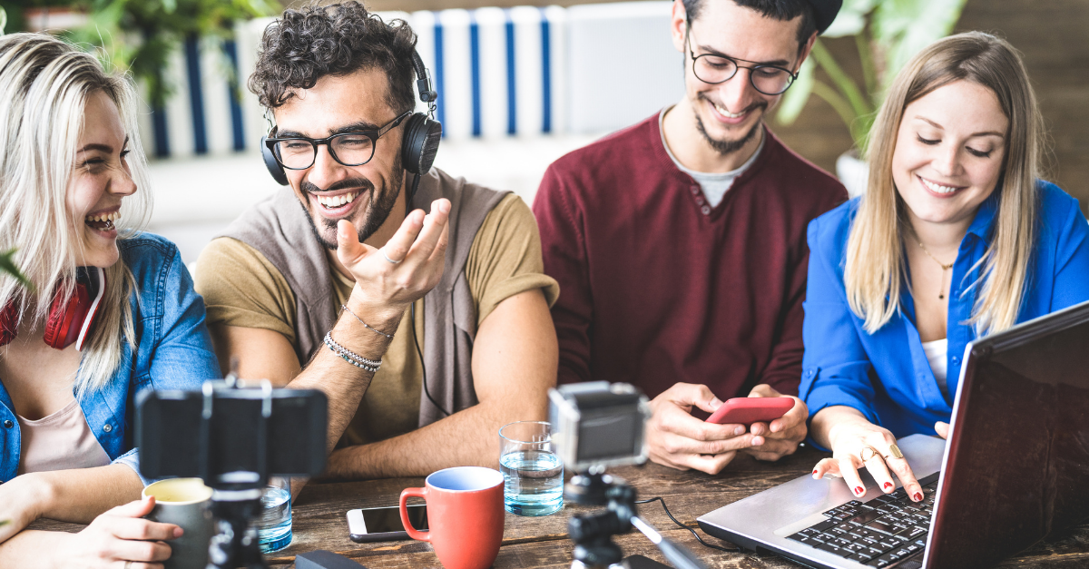 Young happy friends sharing content on streaming platform with digital modern camera